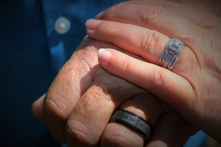 Couple with wedding rings on at a Vow Renewal